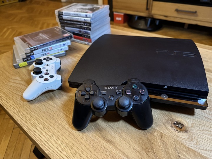 PlayStation 3 Slim z oryginalnymi kontrolerami w kolorze białym i czarnym. Nie widać po nich dużego zużycia, ale mają za sobą długie godziny grania. Źródło: fotografia własna. - To nie była najlepsza premiera Sony. PlayStation 3 kończy 18 lat, ale konsola rozwinęła skrzydła dopiero po czasie - wiadomość - 2024-11-12